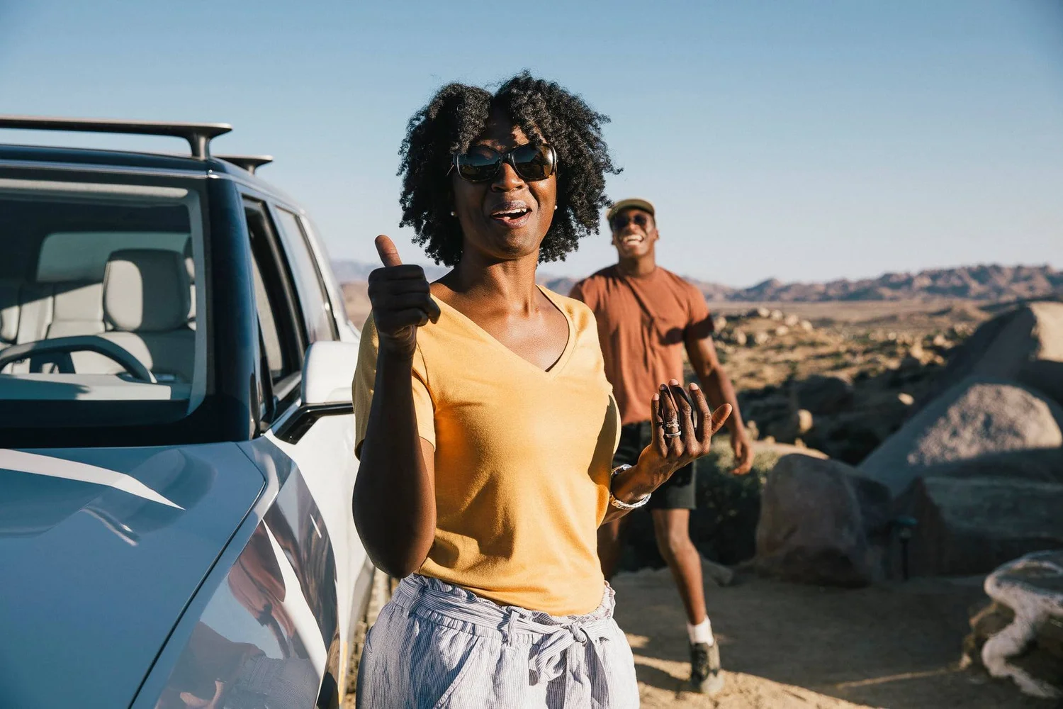 Customer giving a thumbs up next to the Rivian