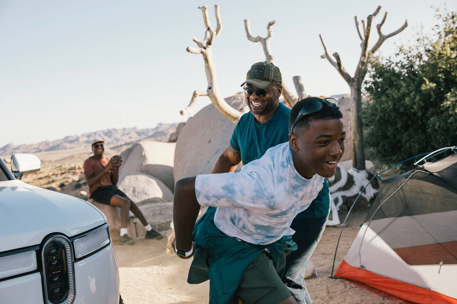 Sykes family laughing at camp beside the Rivian